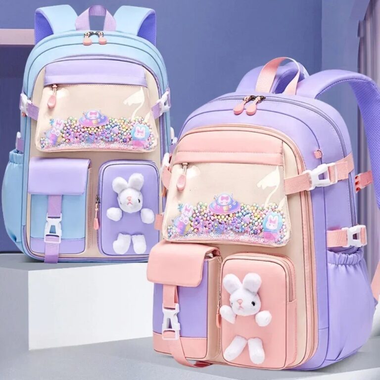 Zwei pastellfarbene Schulranzen für Mädchen der 1. bis 4. Klasse, einer blau und einer violett, jeweils mit einem weißen Plüschhasen, einer durchsichtigen Tasche mit Perlen, rosa Akzenten, mehreren Fächern und gepolsterten Trägern für mehr Komfort – ideal für die Einschulung.